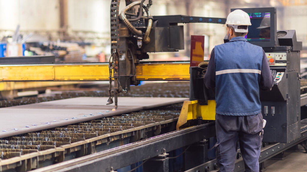 Mitarbeiter steht an Produktionsmaschine
